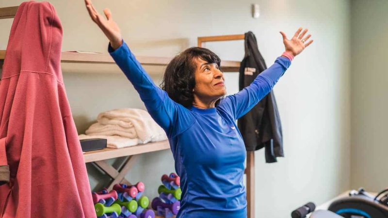 Yoga instructor looking up with arms raised